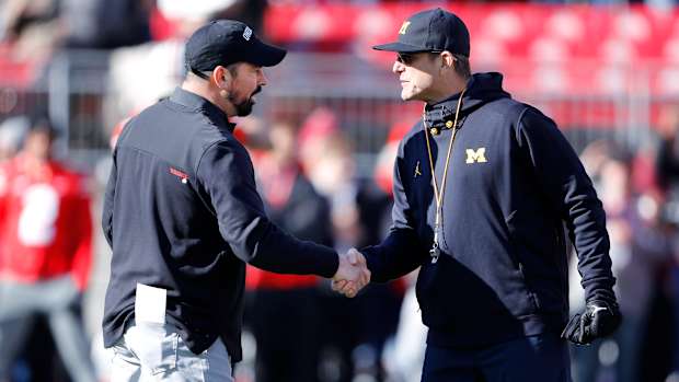 Michigan Wolverines head coach Jim Harbaugh and Ohio State Buckeyes head coach Ryan Day shake hands.